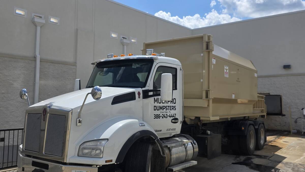 Muckpro truck servicing a commercial compactor in Gainesville, Florida
