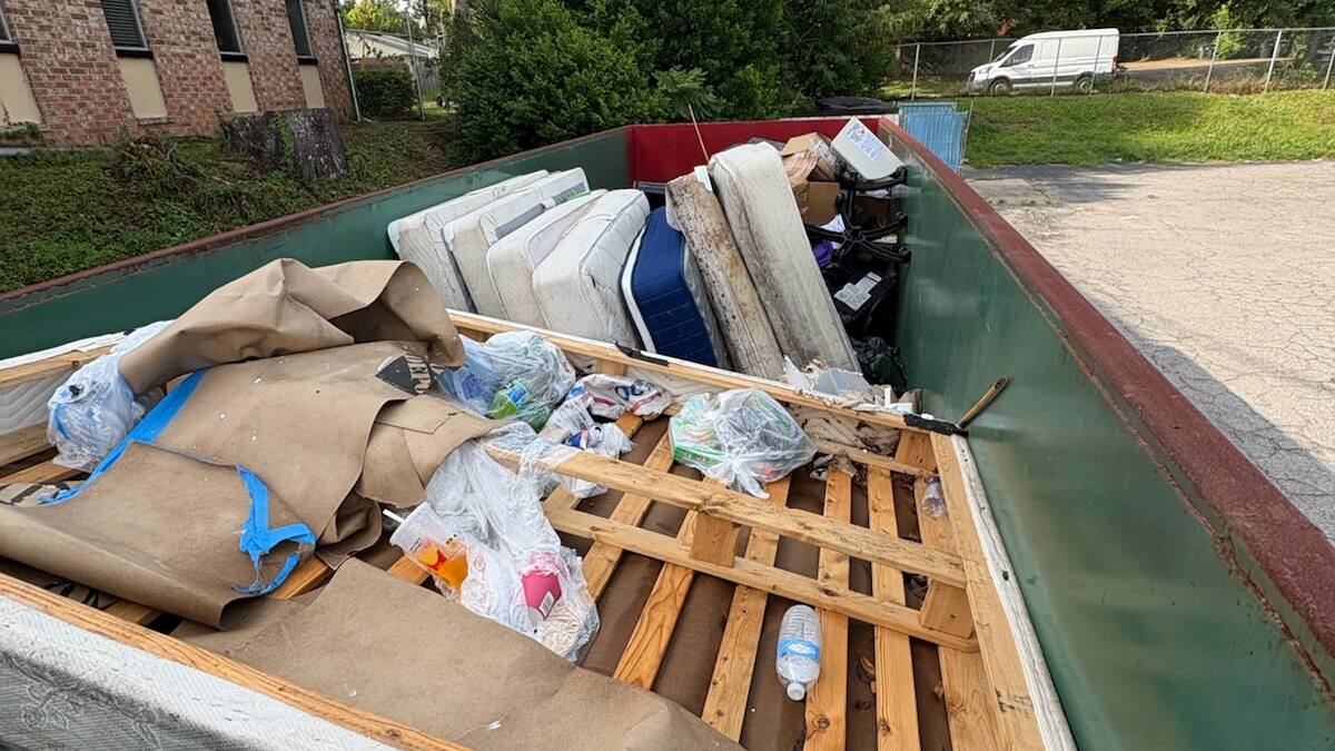40-yard Muckpro dumpster loaded with mattresses during a motel turnover on Apalachee Parkway, Tallahassee