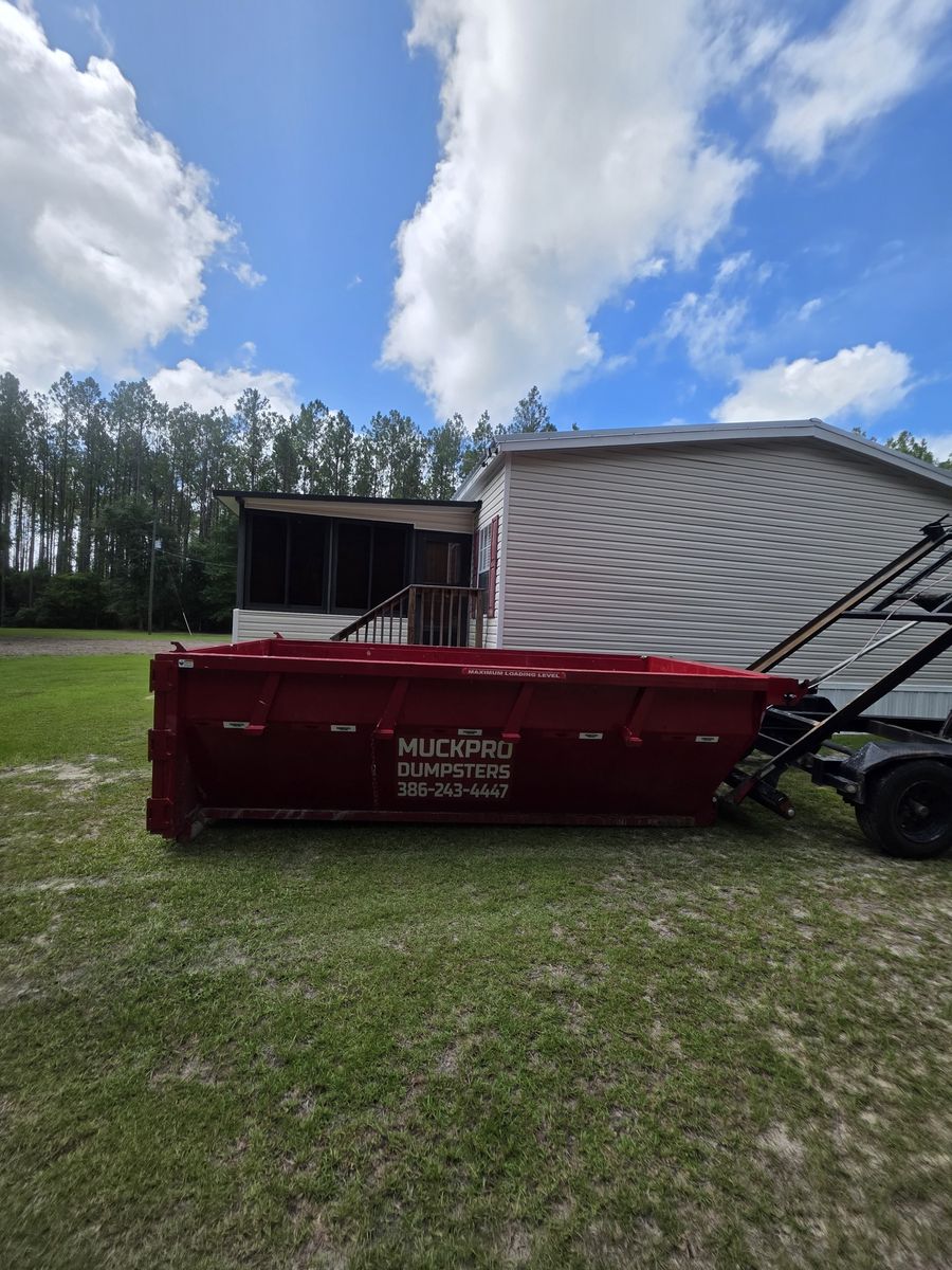 Muckpro roll-off dumpster at a Fort White FL residential driveway