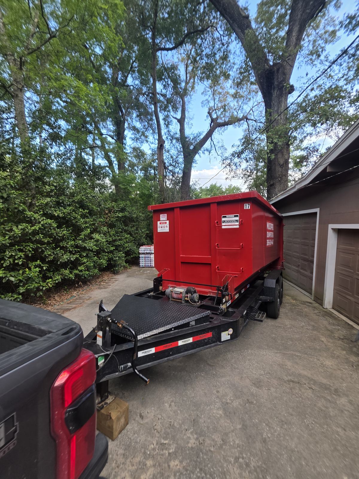 Muckpro trailer dumpster delivery in a tight Gainesville FL driveway
