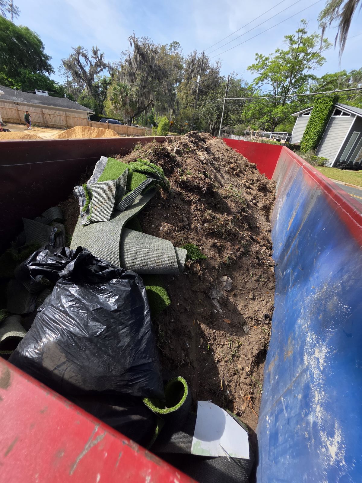 Muckpro dumpster loaded with sod, turf and fill dirt from a Gainesville FL landscaping job
