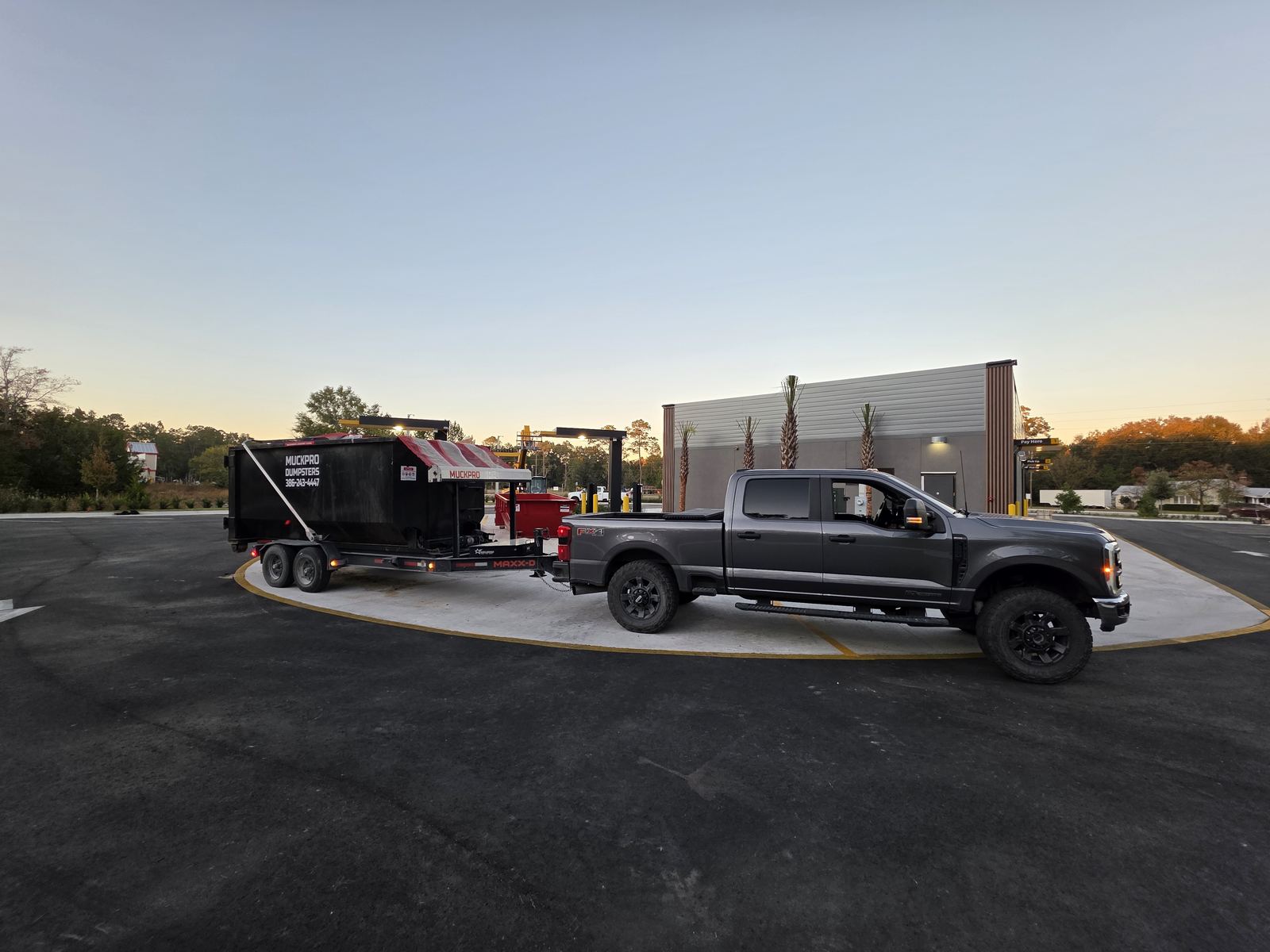 Muckpro trailer dumpster delivery in High Springs FL at sunset