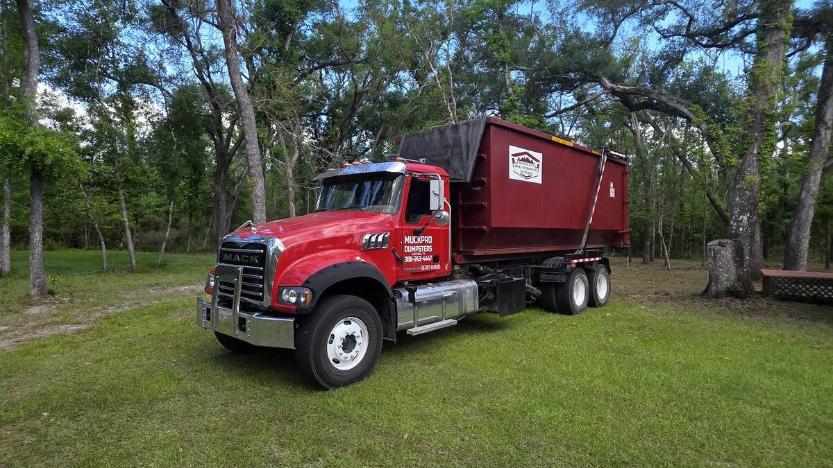 Muckpro Mack truck hauling a 40-yard dumpster near the Suwannee River in Live Oak