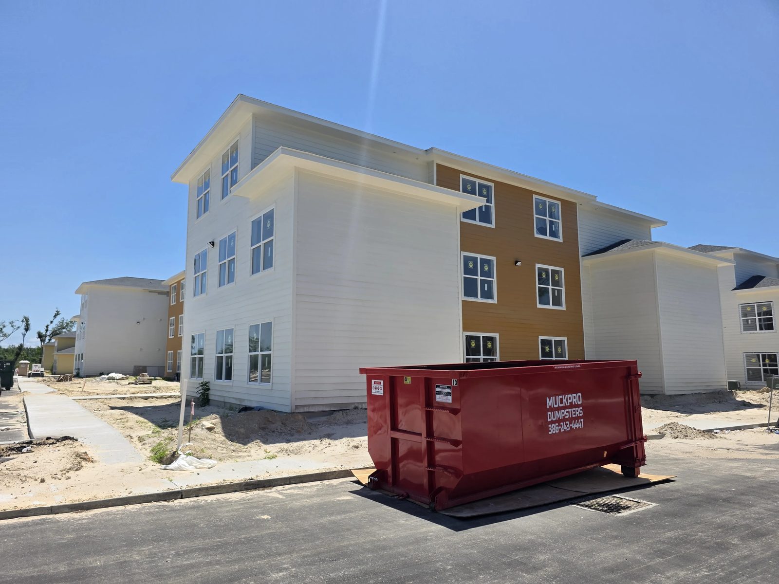 Muckpro roll-off dumpster at a multifamily construction site in North Florida