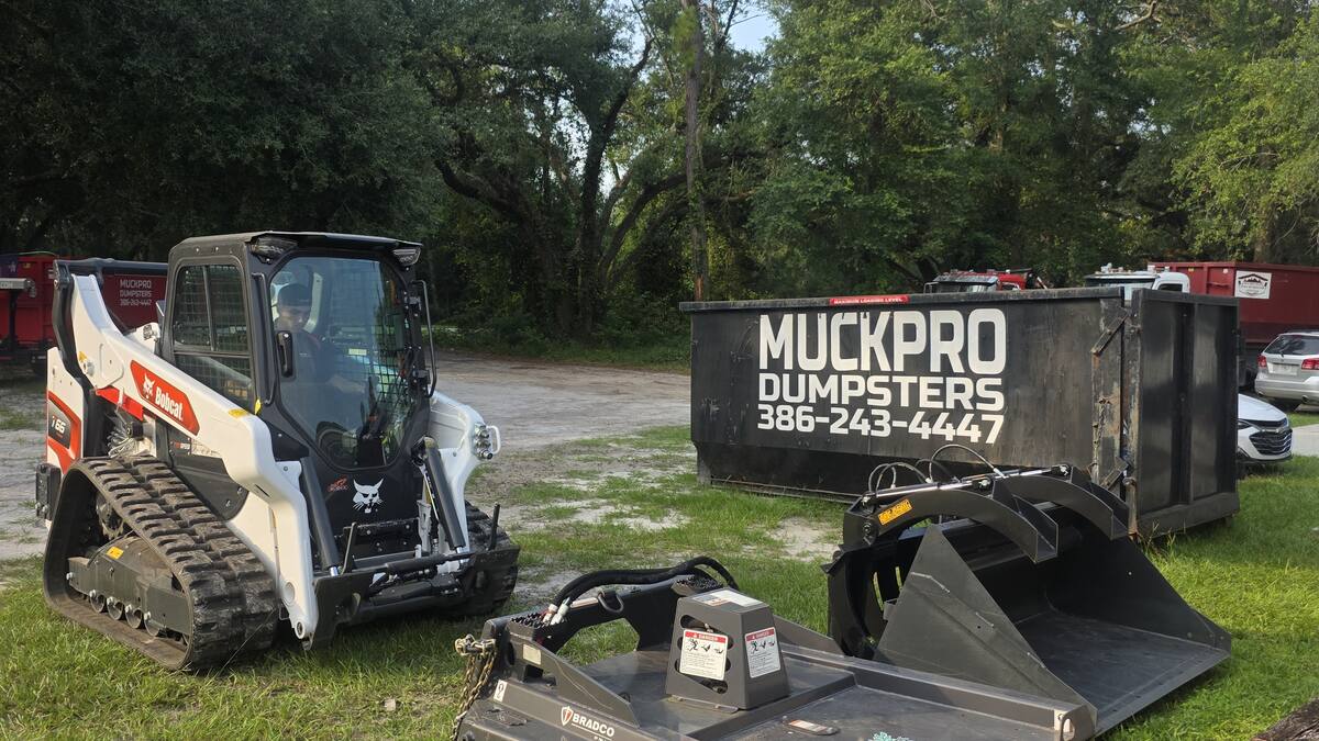 Bobcat T66 compact track loader with bucket, root grapple, and Bradco brush cutter attachments