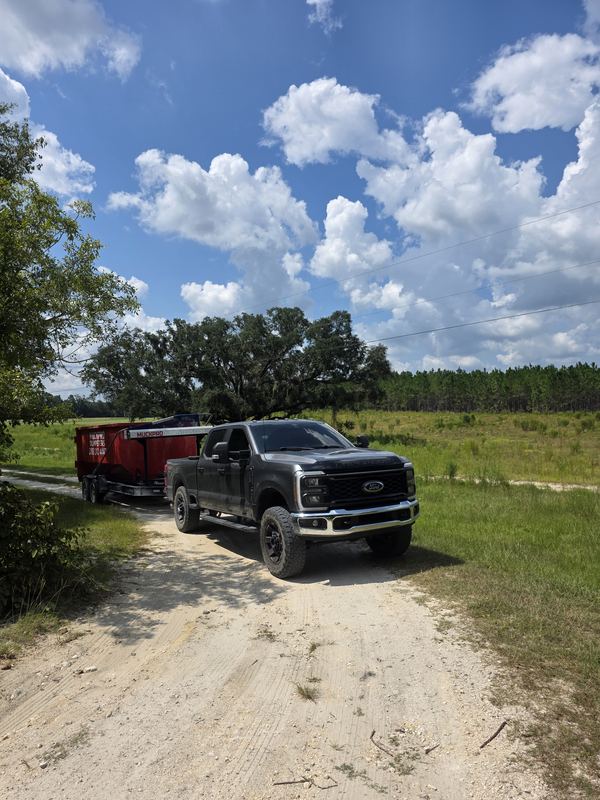 Muckpro truck and dumpster trailer on a Live Oak FL farm road