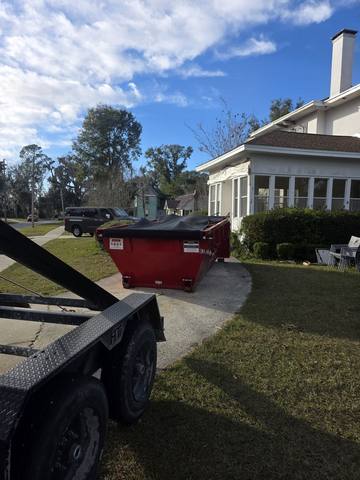 Tarped Muckpro dumpster on a Madison FL residential driveway